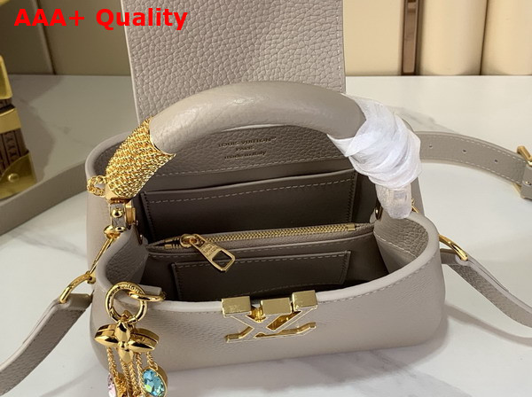 Louis Vuitton Capucines Mini Handbag in Galet Gray Taurillon Leather Embellished with Tonal LV Initials and a Decorative Stone Embellished Charm Replica